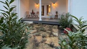 A modern house with a covered porch, stone pathway, and potted plants. - Belle Louise Historic Guest House (Paducah)