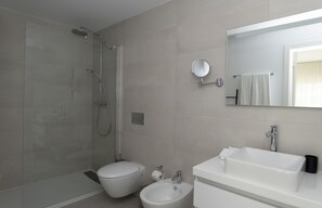 Tina con regadera, secadora de cabello, bidet, toallas 