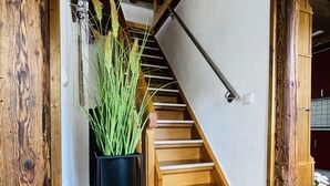 A wooden staircase with a black metal frame on the left, leading to a white wall. - Historic vacation home on the Main, 110 sqm, large terrace, modern and renovated (Mainz-Kostheim)