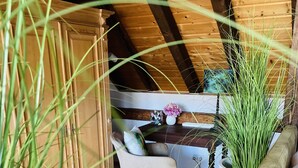 A cozy room with a wooden ceiling, a dining table with chairs, a sofa, and a potted plant. - Historic vacation home on the Main, 110 sqm, large terrace, modern and renovated (Mainz-Kostheim)