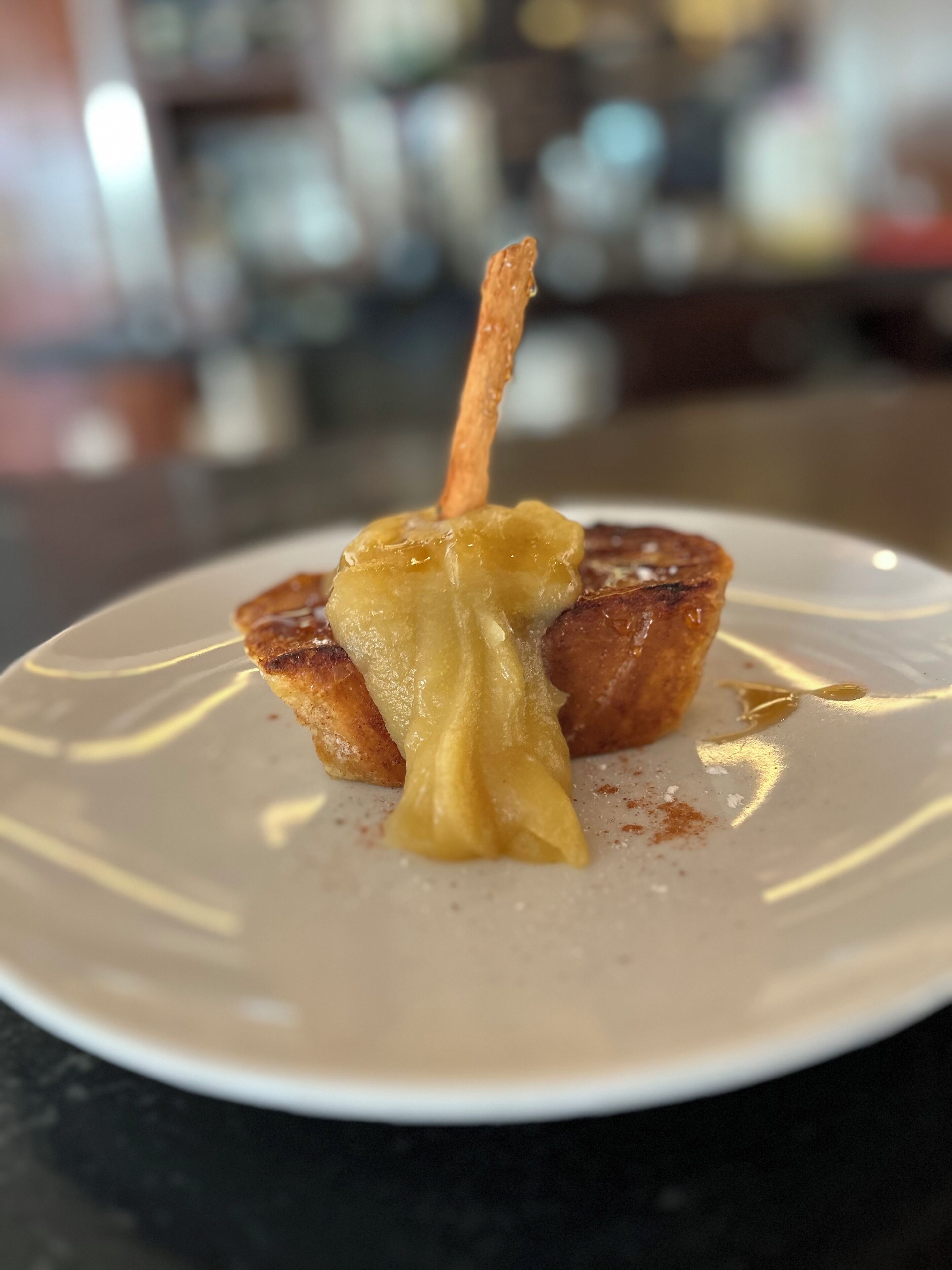 Dessert på hvid tallerken med en karamelliseret æble og karamelglasur.