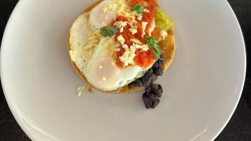 A plate with a breakfast dish on a dark countertop.