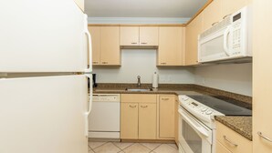 Una cucina dotata di lavastoviglie, fornello, microonde e lavello.