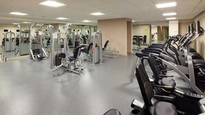 A gym with various exercise machines, mirrors, and a clean, well-lit environment. - Luxury Stay | Near Rockefeller | City Views & W/D (New York)