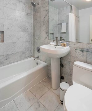 A modern bathroom with a bathtub, sink, and toilet.