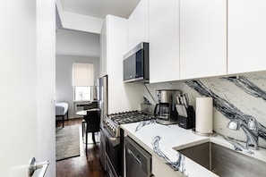 A modern kitchen with a stove, microwave, and sink.