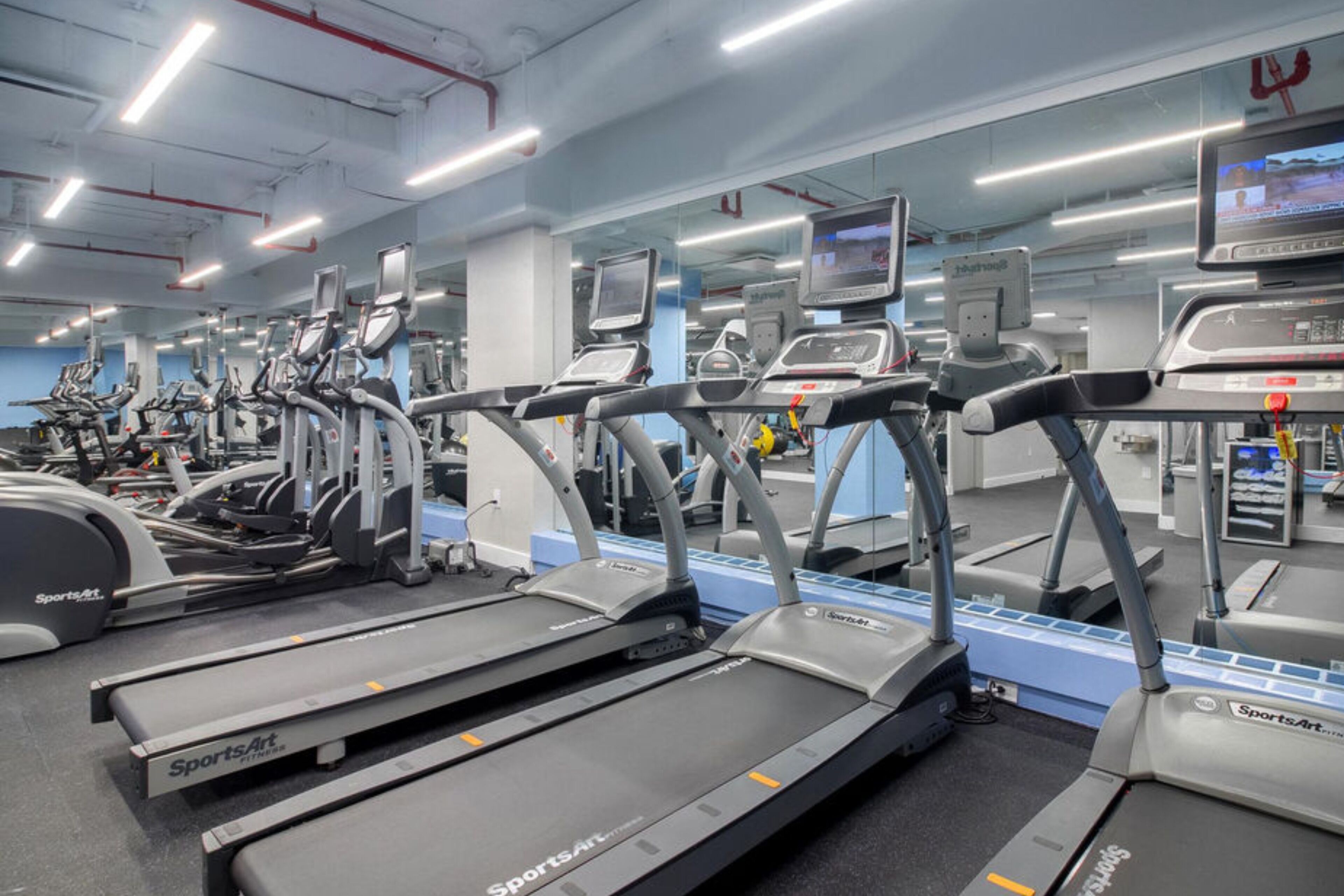 A gym with multiple treadmills and exercise equipment.