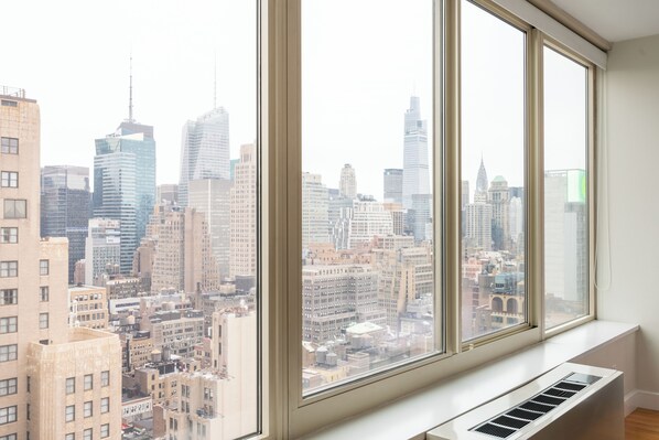 A room with large windows overlooking a cityscape.