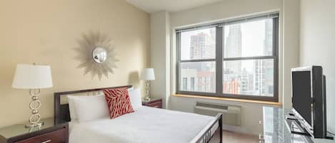 A hotel room with a large bed, two bedside tables with lamps, a TV, and a window with a city view.