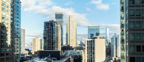 A cityscape with high-rise buildings, including a prominent skyscraper with a unique design.