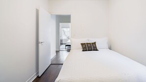 Un dormitorio con una cama grande, una puerta que da a otra habitación y vistas al baño.