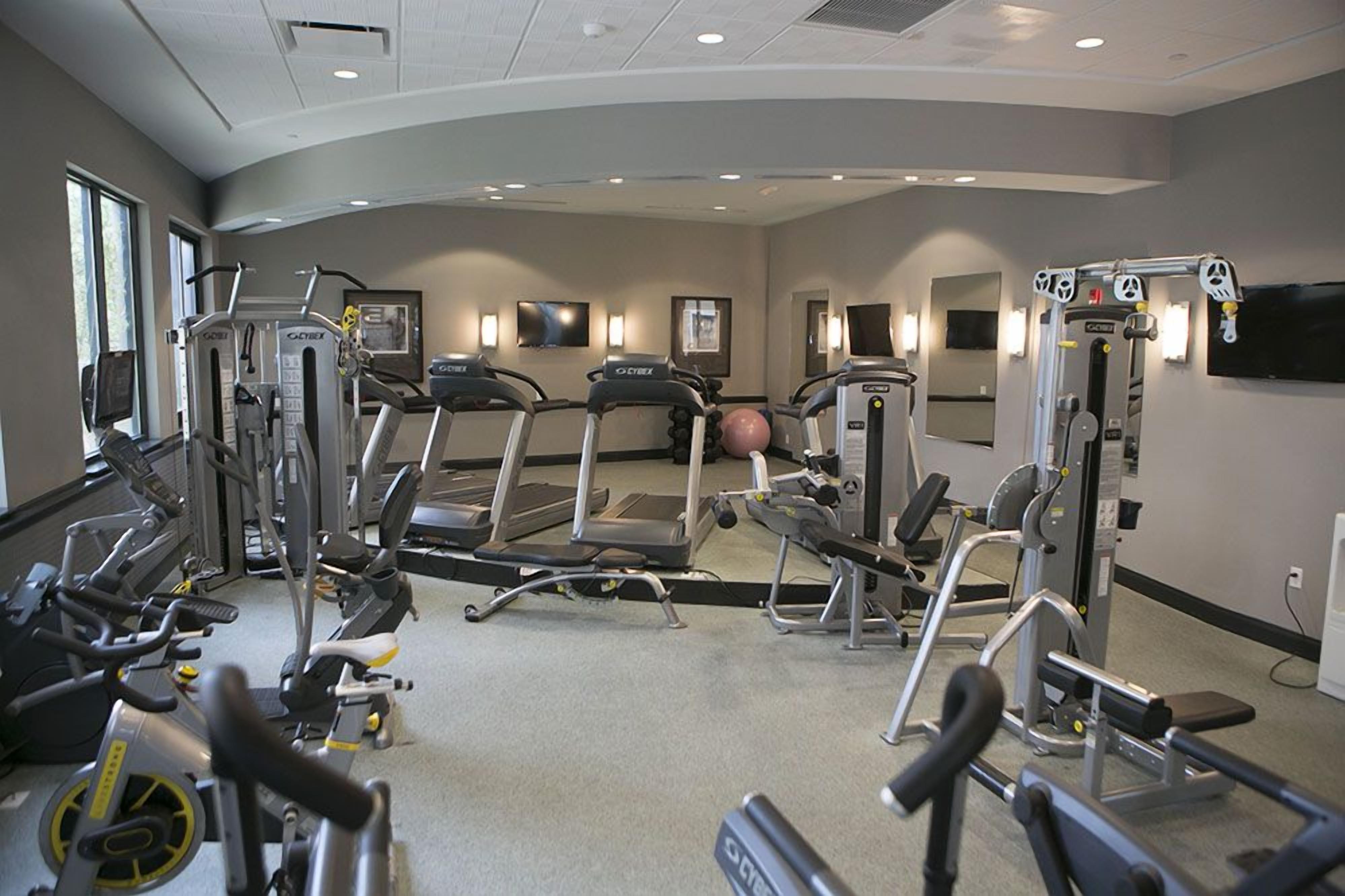 A gym with treadmills, elliptical machines, and weight equipment.