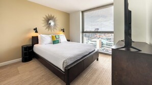 A modern hotel room with a large bed, a city view, a flat-screen TV, and a unique wall decoration. - Boston 2 Bedroom, Across from Fenway Park (Boston)