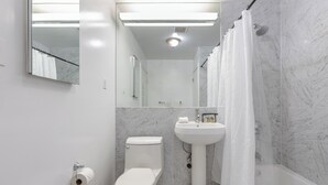 Un baño moderno con inodoro, lavamanos y zona de ducha.