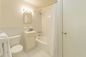 Een badkamer met toilet, wastafel en bad.