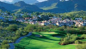 A golf course with a view of residential buildings and mountains in the background. - Water Oasis + Golf Course + Spa! 1 Bedroom Suite. (Phoenix)