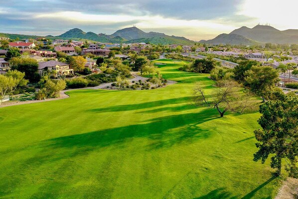 A golf course with a well-maintained green, surrounded by residential buildings and trees. - 1 Bedroom Suite + Balcony | Golf Course + Pools (Phoenix)