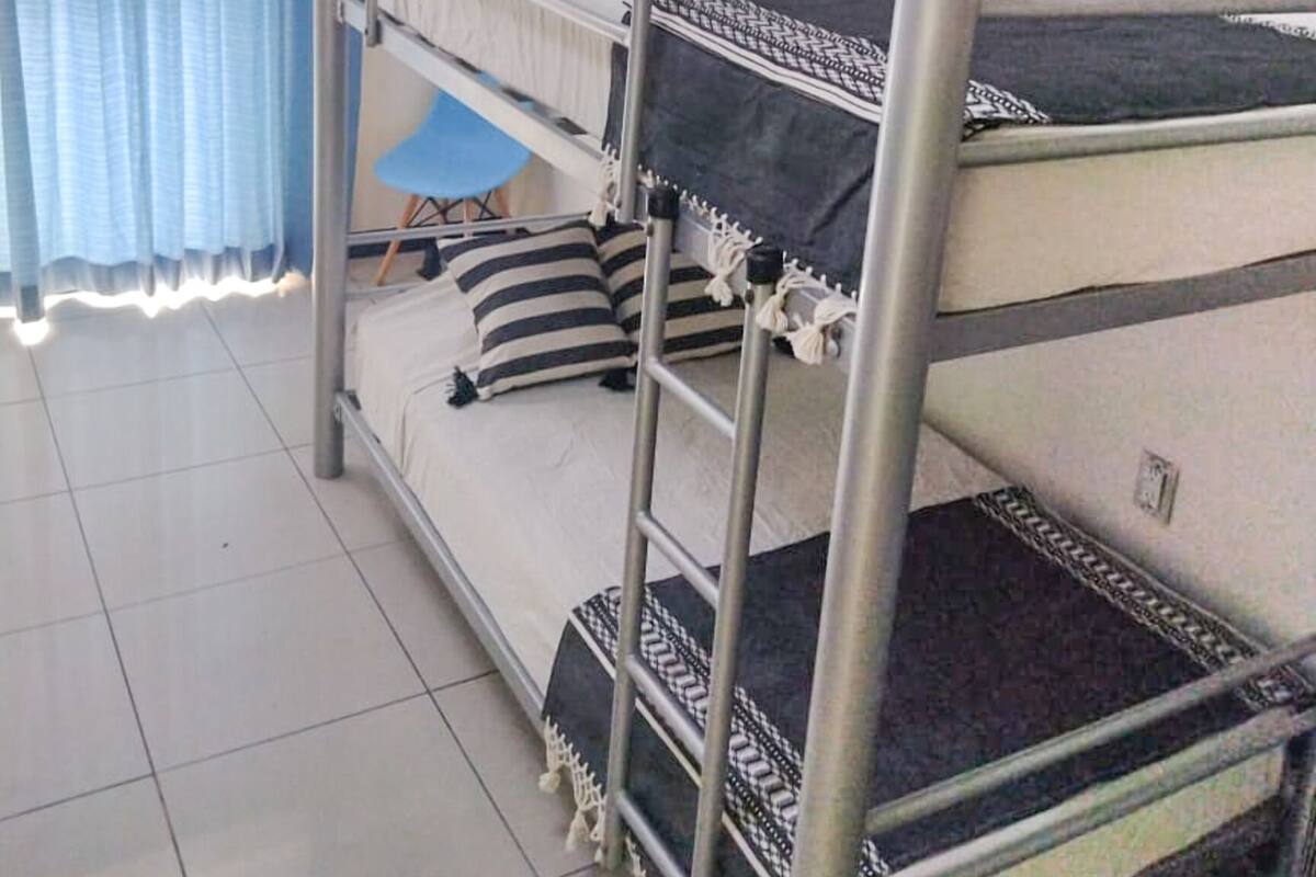 A bunk bed room with a window and curtains.