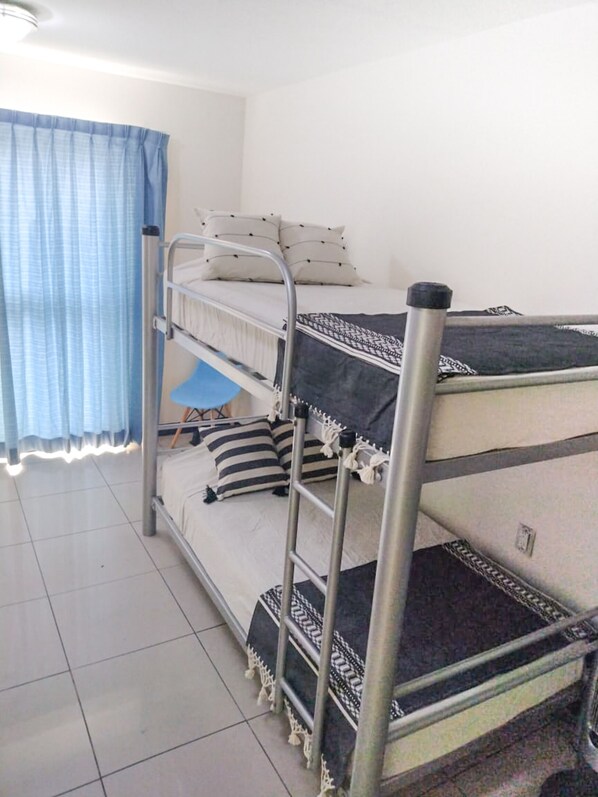 A bunk bed room with a window and curtains. - Esencia Hostal Terminal Oaxaca (Oaxaca)
