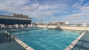 A swimming pool with lounge chairs and a lifeguard stand. - ⭐️Astoria 207 Ocean/Bayside Views Rooftop Pool Linens⭐️ (Ocean City)