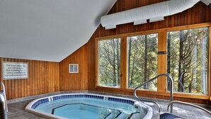 A wooden-paneled room with a pool, large windows, and a sign about security. - Snow Better Place: Perfect for Two - On Shuttle Route w/ Amenities (Killington)