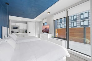 Enjoy a comfortable stay in this stylish room featuring a large bed, wardrobe, kitchenette, and balcony with city views.