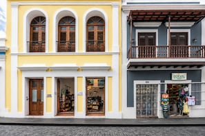 Un edificio de dos pisos con una tienda en la planta baja y un balcón en el piso superior.