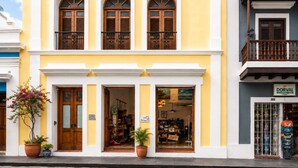 Ein gelbes Gebäude mit drei Rundbogenfenstern und einem Balkon.