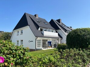Ein zweistöckiges Haus mit dunklem Dach, weißen Außenwänden und dem Namen 'Christian'.