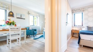 Une pièce moderne et bien éclairée, comprenant un coin repas, un espace salon confortable et une chambre à coucher.