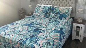 Une chambre à coucher avec un lit, une table de chevet, une lampe et un tableau au mur.