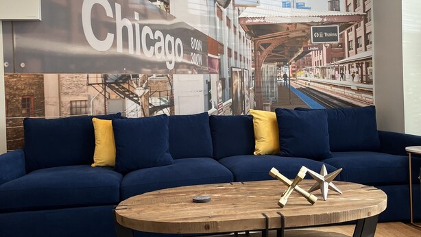 A modern living room with a blue sofa, wooden coffee table, and a large mural of Chicago's skyline. - Trendy West Town Flat - 2 bed / 1.5 bath with parking (Chicago)