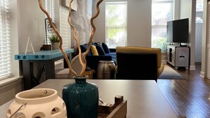 A modern living room with a sofa, a coffee table, and decorative vases. - Trendy West Town Flat - 2 bed / 1.5 bath with parking (Chicago)