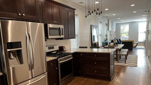 A modern kitchen with stainless steel appliances, dark wooden cabinets, and a granite countertop. - Trendy West Town Flat - 2 bed / 1.5 bath with parking (Chicago)