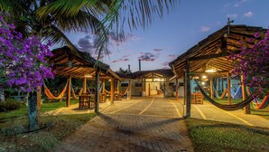 A courtyard with a brick pathway leading to a building with a covered entrance. - Hotel Pousada Villa Itália (Olímpia)