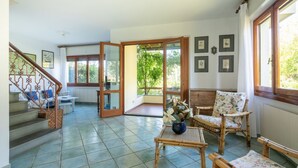 A spacious living area with a staircase, a dining table, and chairs. - Villa Luia by MMega Villas  (Marina di Pietrasanta)