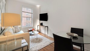 Ein modernes Wohnzimmer mit Sofa, Couchtisch und einem Glastisch für das Esszimmer.