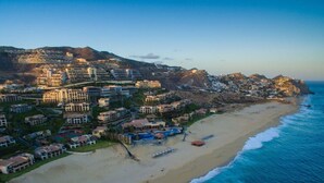 A coastal resort with beachfront villas, a swimming pool, and a beach area.