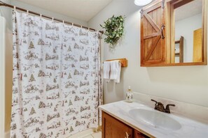 A bathroom with a shower curtain featuring a winter scene, a wooden cabinet, a mirror, and a plant on the wall. - Mtn Retreat w/ Fireplace & Game Room - Lazy Bear (Davis)
