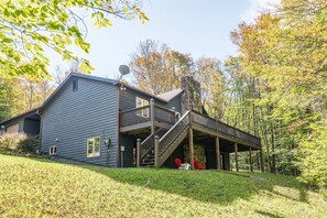 A two-story house with a covered porch and a satellite dish.