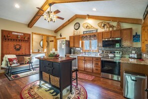 A spacious kitchen with wooden cabinets, a central island, and modern appliances.