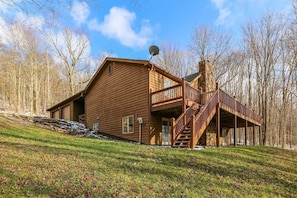 A wooden cabin with a balcony and a satellite dish.