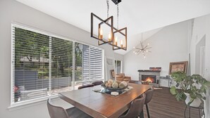 Un comedor con mesa de madera, cuatro sillas y un centro decorativo.