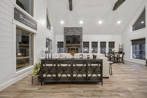 Relax in a spacious living area with a fireplace, comfortable seating, and a large window offering a scenic view.