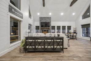 Relax in a spacious living area with a fireplace, comfortable seating, and a large window offering a scenic view.