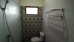 Un baño pequeño con inodoro, ducha y ventana.