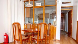 A dining area with a wooden table and chairs, a fire extinguisher, and a sign reading "Karibu Welcome". - 2 Bed Cottage Sleeps 4 - Onsite Parking, Garden (Nairobi)