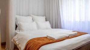 A bed with white bedding and a brown throw blanket, a white pillow, and a white headboard. - 2 Bed Cottage Sleeps 4 - Onsite Parking, Garden (Nairobi)