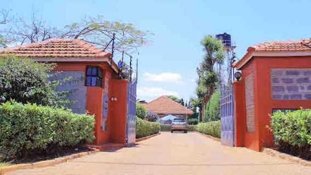 A pathway leading to a building with a red roof and a signboard. - 2 Bed Cottage Sleeps 4 - Onsite Parking, Garden (Nairobi)