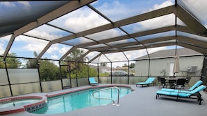 Ein Hallenbad mit Glasdecke, umgeben von Liegestühlen und einer Terrassenanlage.